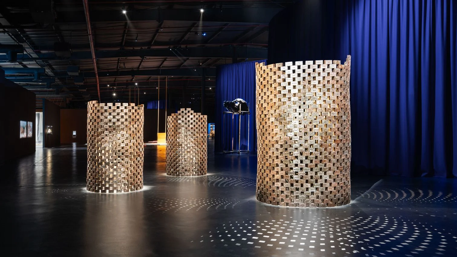 Diriyah Biennale 2026 Launches Poster Design Open Call for Global Creatives 2 2 Exhibition space showcasing cylindrical sculptural installations arranged across a gallery floor under controlled lighting.