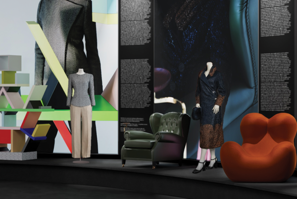Fashion and design exhibition display featuring sculptural furniture, mannequins, garments, and bold visual installations exploring the dialogue between Italian design, craftsmanship, and cultural heritage
